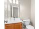 Powder room featuring a vanity with wood cabinets and a large mirror at 102 Winged Foot Ct, Mebane, NC 27302