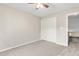A neutral carpeted bedroom featuring closet and ceiling fan at 102 Winged Foot Ct, Mebane, NC 27302