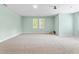 A spacious bonus room with carpet, two windows, and light green walls at 102 Winged Foot Ct, Mebane, NC 27302