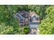 A lovely aerial view of the home with mature trees, a brick facade, and a two-car garage at 102 Winged Foot Ct, Mebane, NC 27302