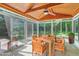 Bright sunroom featuring a wood ceiling, tile floor, large windows, and a dining set at 102 Winged Foot Ct, Mebane, NC 27302