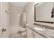 Clean bathroom featuring granite countertops, white cabinets, and shower with gray tiled tub at 10304 Stallion Way, Bahama, NC 27503