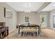 Elegant dining room with modern chandelier, bench seating, and bright natural light at 10304 Stallion Way, Bahama, NC 27503