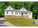 Beautiful two-story home featuring brick accents, white siding, and a covered front porch at 10304 Stallion Way, Bahama, NC 27503