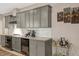 Elegant kitchen with gray cabinets, stainless steel appliances, a wine fridge, and granite countertops at 10304 Stallion Way, Bahama, NC 27503