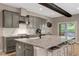 Stylish kitchen featuring gray cabinets, granite countertops, a large island, and a sliding glass door to the deck at 10304 Stallion Way, Bahama, NC 27503