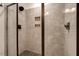 Modern shower with beautiful tile surround and frameless glass doors at 10304 Stallion Way, Bahama, NC 27503