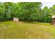 Landscaped backyard featuring mature trees and a shed at 1033 Cabin Hill Way, Garner, NC 27529