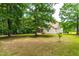 Backyard view of home with large shade trees and screened in porch at 1033 Cabin Hill Way, Garner, NC 27529
