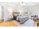 Main bedroom showcasing a tray ceiling, wood floors, and large window with natural light at 1033 Cabin Hill Way, Garner, NC 27529