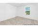 Bright bedroom featuring neutral carpet, white walls, a window, and closet door at 105 Mable Court # 10, Lillington, NC 27546