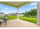 Covered patio overlooking a large backyard with a neighboring houses and treeline at 110 Hickory Grove Dr, Sanford, NC 27330
