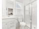 Bright bathroom showcasing a glass-enclosed shower, white vanity, and toilet with large window at 110 Hickory Grove Dr, Sanford, NC 27330