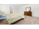 Spacious bedroom featuring neutral colored carpet, a wooden dresser, and two windows at 110 Hickory Grove Dr, Sanford, NC 27330