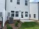 Backyard of a home with a white wall, concrete patio, and grassy area at 1116 Merlot Hills Ln, Durham, NC 27704