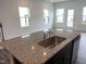 Beautiful granite countertops and a stainless steel sink enhance this modern open-concept kitchen at 1116 Merlot Hills Ln, Durham, NC 27704
