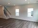 Bright living room with wood floors, recessed lighting, and staircase access at 1116 Merlot Hills Ln, Durham, NC 27704