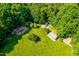 Aerial view of open grassy area with mature trees and play structures perfect for outdoor activities at 114 Bonaparte Dr, Hillsborough, NC 27278