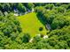 Aerial view of lush green field bordered by trees and residential properties creating a quiet atmosphere at 114 Bonaparte Dr, Hillsborough, NC 27278