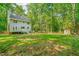 Spacious backyard with a deck and mature trees offering a serene outdoor setting with room to roam at 114 Bonaparte Dr, Hillsborough, NC 27278