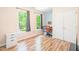 Well-lit bedroom features hardwood floors, two windows, and desk setup at 114 Bonaparte Dr, Hillsborough, NC 27278