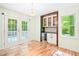 Bright dining area features hardwood floors, French doors, and a bar area with wine fridge at 114 Bonaparte Dr, Hillsborough, NC 27278