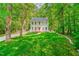 Beautifully landscaped front yard with a charming two-story home nestled among mature trees at 114 Bonaparte Dr, Hillsborough, NC 27278