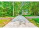 Inviting two-story home with a long driveway and beautifully landscaped front yard with colorful flowers at 114 Bonaparte Dr, Hillsborough, NC 27278