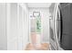 Hallway featuring hardwood floors, closet with louvered doors and stainless steel refrigerator at 114 Bonaparte Dr, Hillsborough, NC 27278