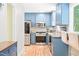 Well-lit kitchen with blue cabinets, stainless steel appliances, and a cozy breakfast bar at 114 Bonaparte Dr, Hillsborough, NC 27278