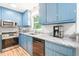 Charming kitchen featuring blue cabinets, stainless steel appliances, and granite countertops at 114 Bonaparte Dr, Hillsborough, NC 27278