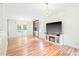 Open living room with hardwood floors, modern fireplace, and stylish light fixtures at 114 Bonaparte Dr, Hillsborough, NC 27278