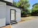 Side exterior view with a white door and gravel landscaping at 114 N Guthrie Ave, Durham, NC 27703