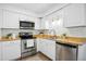 Well-lit kitchen featuring a stainless steel oven, microwave, a sink, and classic white cabinetry at 1208 Manassas Ct # A, Raleigh, NC 27609