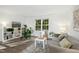 Bright living room featuring hardwood floors, a large window, a comfy couch, and stylish decor at 1208 Manassas Ct # A, Raleigh, NC 27609