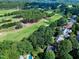Aerial view showcasing homes near the golf course, surrounded by lush trees and mature landscaping at 1217 Briar Patch Ln, Raleigh, NC 27615