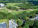 Aerial view capturing a home with pool near the golf course, featuring mature trees and lavish landscaping at 1217 Briar Patch Ln, Raleigh, NC 27615