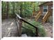 Cabin with back deck and stairs surrounded by lush green trees and greenery at 125 Forsyth Dr, Chapel Hill, NC 27517