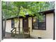 Tan cabin with front door, steps and small deck surrounded by tall trees at 125 Forsyth Dr, Chapel Hill, NC 27517