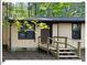 Tan cabin with front door, steps and small deck surrounded by tall trees at 125 Forsyth Dr, Chapel Hill, NC 27517