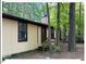 Tan cabin with front door, steps and small deck surrounded by tall trees at 125 Forsyth Dr, Chapel Hill, NC 27517