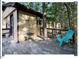 Side deck with table, adirondack chair surrounded by lush green trees and greenery at 125 Forsyth Dr, Chapel Hill, NC 27517