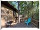Side deck with table, adirondack chair surrounded by lush green trees and greenery at 125 Forsyth Dr, Chapel Hill, NC 27517