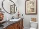 Powder room features ornate vanity with a black countertop, stylish mirror, and vintage decor at 12500 Richmond Run Dr, Raleigh, NC 27614
