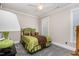 Cozy bedroom with large lamp, green decor and patterned carpet at 12500 Richmond Run Dr, Raleigh, NC 27614