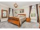 Charming primary bedroom with a wooden bed frame, neutral color scheme, and large windows at 12500 Richmond Run Dr, Raleigh, NC 27614