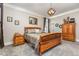 Primary bedroom features a wood bed frame, neutral walls, decorative light fixture, and carpet flooring at 12500 Richmond Run Dr, Raleigh, NC 27614