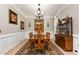 Formal dining room featuring a chandelier, wainscoting, wooden furniture, and large rug at 12500 Richmond Run Dr, Raleigh, NC 27614