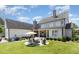 Expansive backyard features a fire pit area with seating, a covered patio, and lush landscaping at 12500 Richmond Run Dr, Raleigh, NC 27614