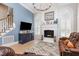 Elegant living room with a fireplace, arched windows, and access to kitchen and stairs at 12500 Richmond Run Dr, Raleigh, NC 27614